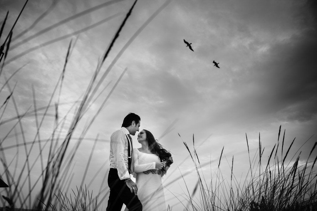 fotos de boda en la playa con una pareja que vuela alto
