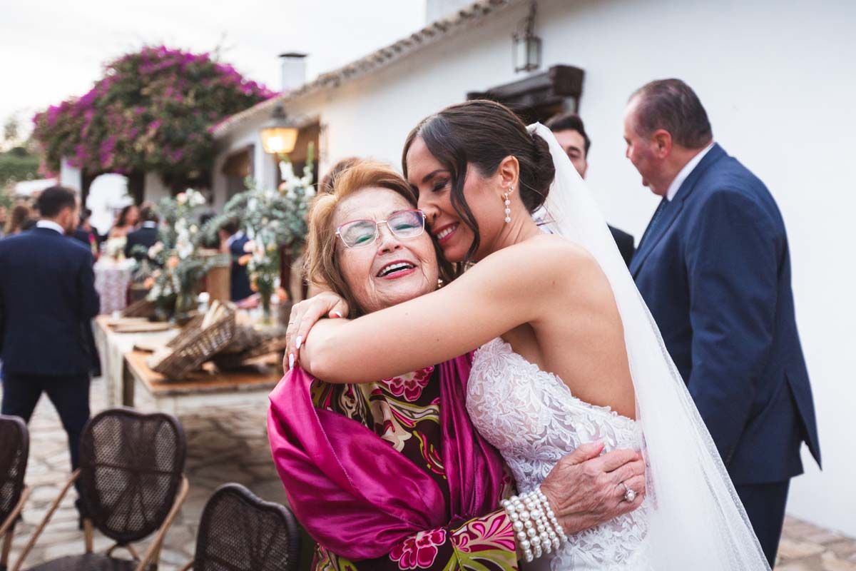 Fotógrafo en Córdoba novia abrazando a su abuela en la copa de bienvenida